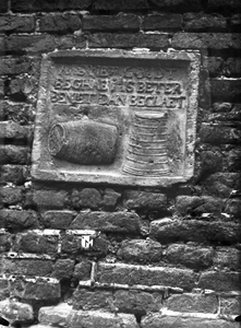 67698 Afbeelding van de gevelsteen, voorstellende destilleerattributen in de vorm van een liggende en staande ton met ...